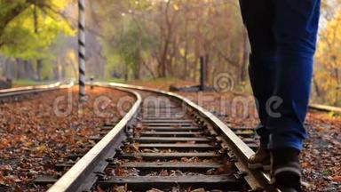 <strong>一个人</strong>走下火车轨道的背景金色秋天的森林。 <strong>一个人</strong>离开摄像机