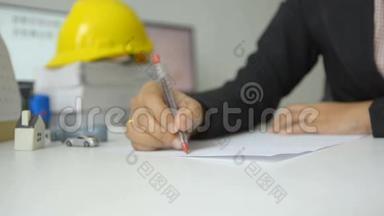 女人的手用红笔在白纸上画画，男人的手指着白纸，指着白纸的方向