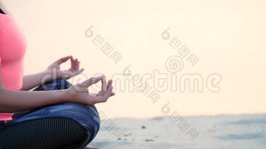 健康，年轻的美丽女子冥想，在海滩上练习瑜伽，海边，日出时，放松肌肉，放松心灵
