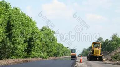 修复一条公路、压路机和沥青<strong>修整</strong>机，铺设一条新的新鲜沥青路面，覆盖在一条公路上