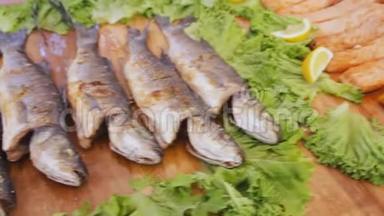 烤红鲑鱼加沙拉。 在<strong>美食节</strong>的餐桌上放着蔬菜和柠檬的煮熟的鱼片。
