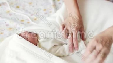 妇产医院-母亲正在医院里襁褓一个新生婴儿