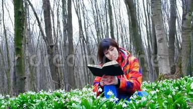 一个漂亮聪明的女孩正在春天的森林里读一本有趣的书，里面满是<strong>朵朵</strong>的雪花