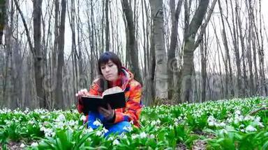 一个漂亮聪明的女孩正在春天的森林里读一本有趣的书，里面满是朵朵的雪花