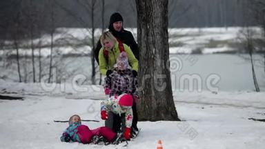 当一家人试图在雪地上踩大滑雪板时，孩子摔倒了