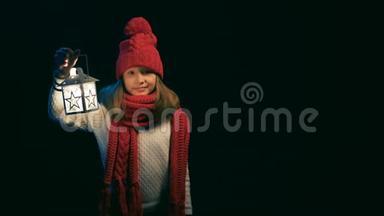 小女孩戴着针织冬帽围巾提着灯笼散步