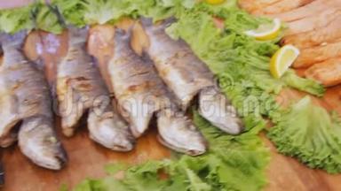 烤红鲑鱼加沙拉。 在美食节的餐桌上放着蔬菜和柠檬的煮熟的鱼片。