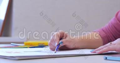 年轻的艺术家的手，女艺术家用石墨<strong>铅笔画画</strong>布，坐在桌子上<strong>画画</strong>布