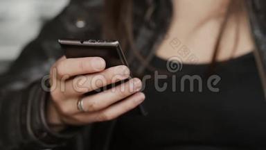 女孩双手特写用智能手机上网，坐在现代咖啡馆里。