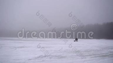 无法辨认的人在冰冻的湖面上行走