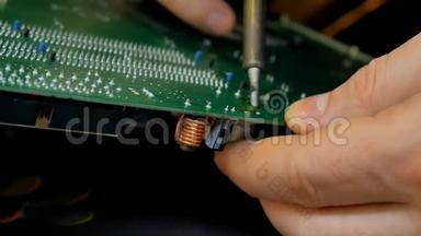 电子工程师正在焊接一台电板修理计算机。