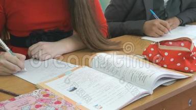 两个学生用圆珠笔写作业本