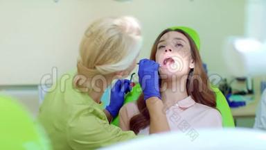 牙医用嘴镜检查病人的牙齿。 <strong>口腔</strong>医生和病人