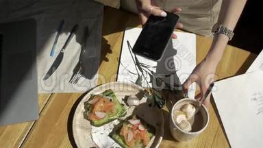 手拿手机特写食物<strong>图片</strong>.. 两人早餐：三明治，<strong>咖啡</strong>，吐司。
