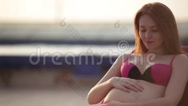 红头孕妇穿着泳衣在<strong>泳池</strong>边晒日光浴。 <strong>夏日</strong>心情