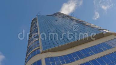 一座现代化的城市办公楼，玻璃立面，天空倒影。 摩天大楼