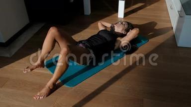 女人在垫子上做身体弯曲和扭转，而躺在地板上。