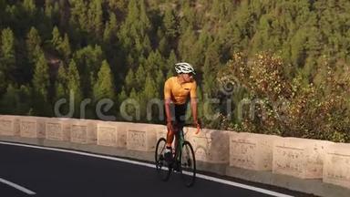 一个骑着运动型<strong>公路</strong>自行车的人在山上的<strong>公路</strong>上<strong>骑车</strong>