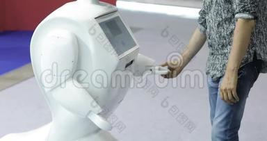 一个人与一个机器人交流，把一个塑料机械手臂按到机器人上，与机器人握手。 斯奇菲。 现代
