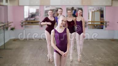 一位年轻的女孩芭蕾舞演员穿着淡紫色芭蕾舞紧身衣的肖像，微笑着，优雅地表演着芭蕾舞的身影。