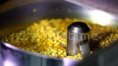 全自动旋转爆米花机的特写镜头，打开盖子，用甜焦糖酱混合小玉米种子
