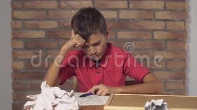 坐在书桌前的孩子拿着一张挂图，上面写着红色砖墙上的刻字图案