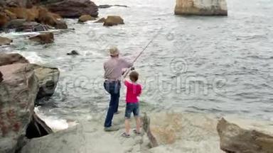 带小孩的老人把鱼竿扔到海里