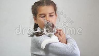 女孩和小猫。 小猫在玩咬人的游戏，十几岁的女孩在室内抱着一只小猫。 少女和猫