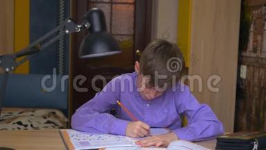 一个十几岁的男孩做家庭作业。 远程教育。 家庭教育