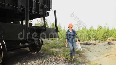 一个年轻的女<strong>火车司机</strong>检查货车的车轴箱。