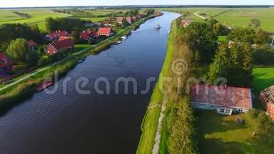 靠近河边的村庄。 阳光明媚的夏日，无人机在河边的一个小村庄里拍摄。