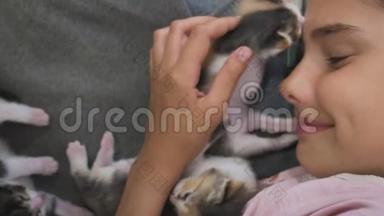 女孩和两只可爱的小猫的概念-快乐的小女孩和猫在床上在家里。 女学生宝宝和猫爱宠物