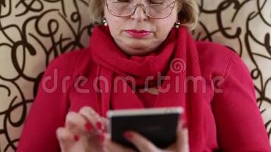 老妇人坐在沙发上，用<strong>电子书</strong>。 带<strong>电子书</strong>的女人