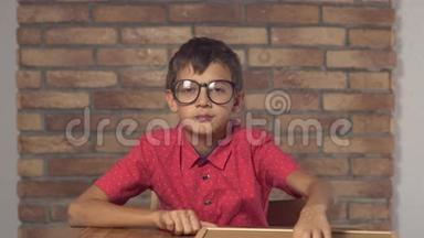 坐在书桌前的孩子拿着一张挂图，上面写着红色砖墙上的公关字样
