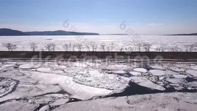 一架无人机飞过结冰的河流，水和冰在结冰的河流上