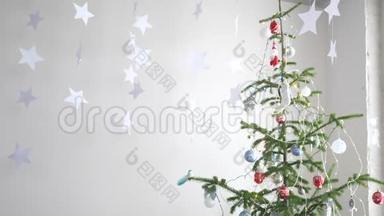 纸上的星星挂在窗户旁边的冷杉树旁边，作为圣诞节内部的背景。 圣诞节的概念。 新
