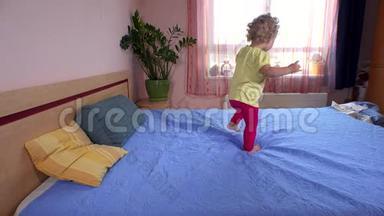 <strong>嬉戏</strong>的小女孩在卧室的床上蹦蹦跳跳地跑