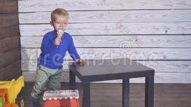 坐在高椅子上吃<strong>冰淇淋</strong>的男孩。 可爱的孩子在华夫饼锥里享受<strong>冰淇淋</strong>。 看着。