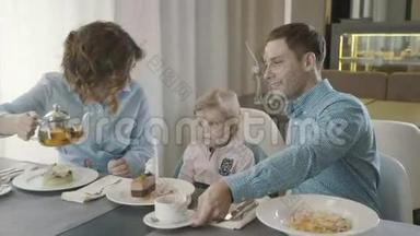 一家餐馆里有个小孩的家庭：爸爸、妈妈和女儿