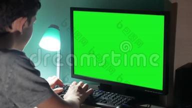 绿色钥匙室内青少年男孩玩电脑特写手游视频后坐.. 青年室内学生考试