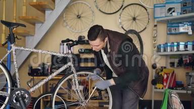 英俊的男机修<strong>工</strong>正在用专业<strong>工</strong>具修理自行车车轮，同时独自在小作<strong>坊工</strong>作。