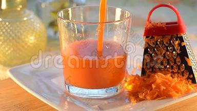 胡萝卜汁倒入一个玻璃烧杯中，杯子站在桌子和盘子上。 有选择的焦点。