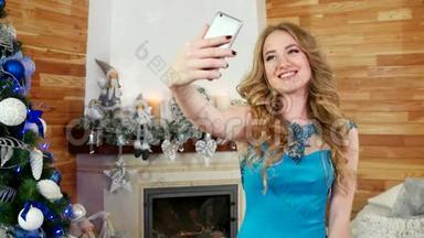 女孩自拍，一部手机的圣诞照片，一个圣诞树上的节日派对，一个漂亮的女孩用手机