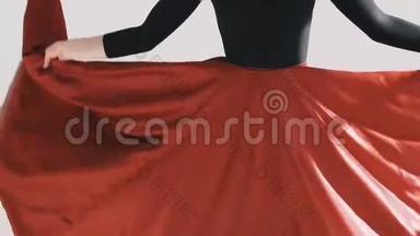 女人穿着一条飘舞的红色裙子。 红布飘舞。