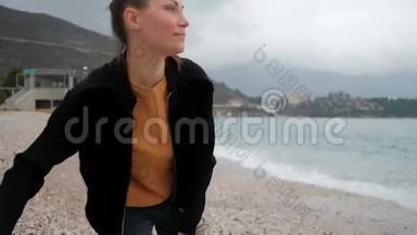 站在黑山海滩上的女人向湖边扔石头。