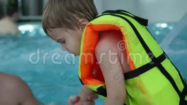 一位带着孩子的年轻父亲在水疗池里游泳。 在游泳池里放松和娱乐