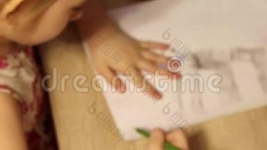 可爱的小女孩在桌上用毛毡尖笔和铅笔画画。 幼儿绘制俯视图..