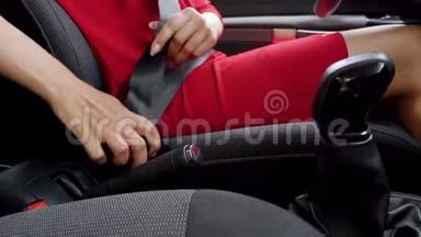 在驾驶前，身着红色礼服的女士在车<strong>内</strong>系紧<strong>安全带</strong>