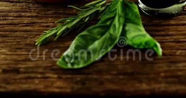 木制桌子上的草药和一碗红橄榄