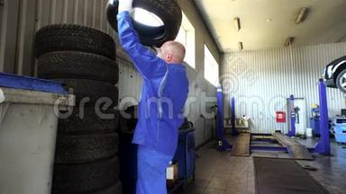 男人在车库里堆放磨损的轮胎。 轮胎更换和储存服务。